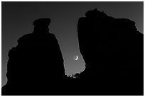 Crescent moon framed by Dollhouse spires. Canyonlands National Park, Utah, USA. (black and white)