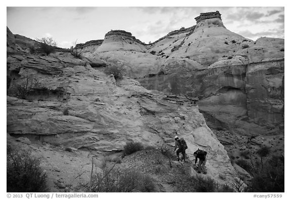 Hikers climbing out of High Spur slot canyon, Orange Cliffs Unit, Glen Canyon National Recreation Area, Utah. USA (black and white)