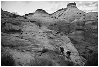 Hikers climbing out of High Spur slot canyon, Orange Cliffs Unit, Glen Canyon National Recreation Area, Utah. USA (black and white)