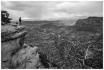 Park visitor looking, Wingate Cliffs at Flint Trail overlook. Canyonlands National Park, Utah, USA. (black and white)