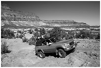 4WD vehicle driving over rocks in Teapot Canyon. Canyonlands National Park, Utah, USA. (black and white)