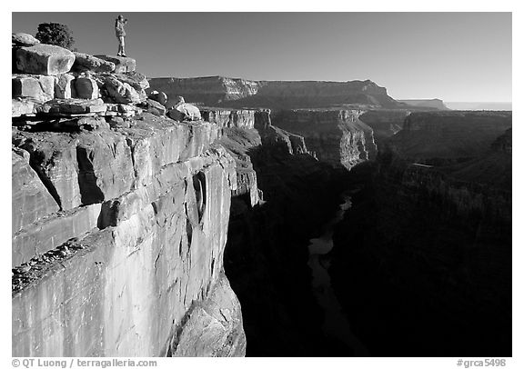 Hiker looking down into  Grand Canyon at Toroweap, early morning. Grand Canyon National Park, Arizona, USA.