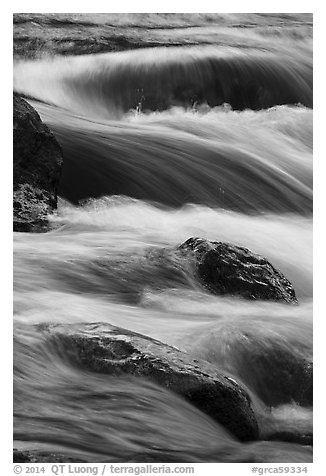 Boulders and rapids with warm light from canyon walls reflected. Grand Canyon National Park (black and white)