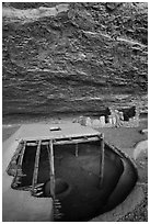 Reconstructed pithouse and original walls below rock roof, Step House. Mesa Verde National Park ( black and white)