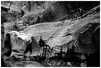Canyoneers in wetsuits rappel down walls of the Subway. Zion National Park, Utah, USA. (black and white)