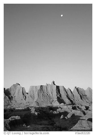 Moon and erosion formations, Cedar Pass, dawn. Badlands National Park, South Dakota, USA.