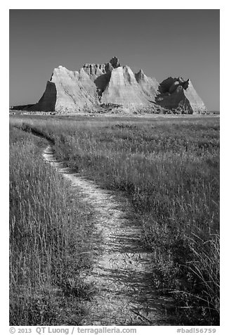 Trail winding in prairie next to butte. Badlands National Park, South Dakota, USA.