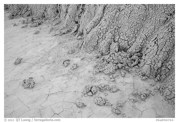 Base of butte with mudstone rolling onto flat soil. Badlands National Park, South Dakota, USA.