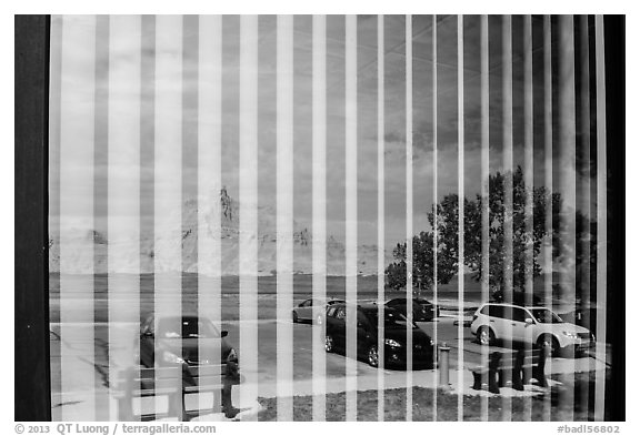 Badlands and parking lot, Visitor Center window reflexion. Badlands National Park, South Dakota, USA.