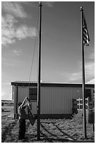 Ranger lowering Ogala Lakota flag, White River Visitor Center. Badlands National Park, South Dakota, USA. (black and white)