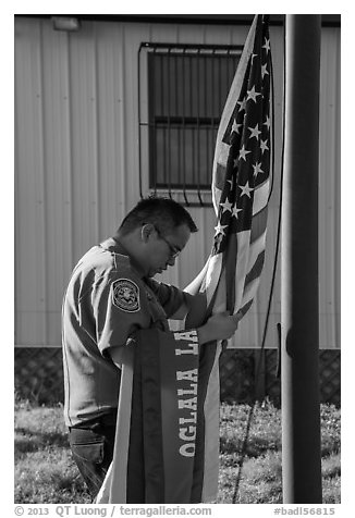 Native American ranger gathering US and Tribal flags. Badlands National Park (black and white)