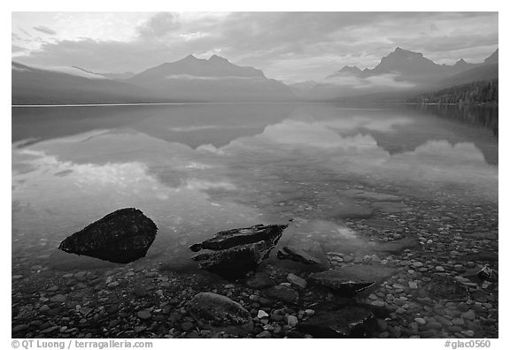 Rocks, peebles, and mountain reflections in lake McDonald. Glacier National Park, Montana, USA.