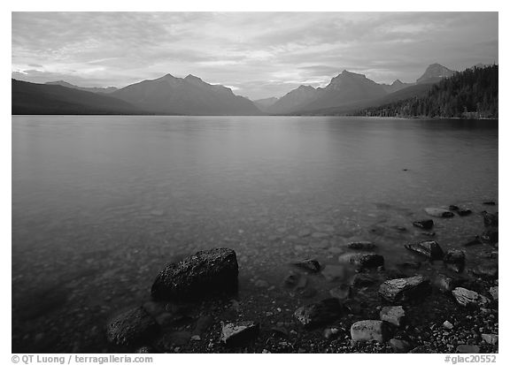 Rocks, Lake Mc Donald, and mountains at sunset. Glacier National Park, Montana, USA.