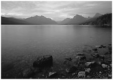 Rocks, Lake Mc Donald, and mountains at sunset. Glacier National Park, Montana, USA. (black and white)