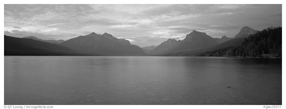 Mountains rising above calm lake in the evening. Glacier National Park (black and white)