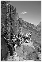 Walking under a small waterfall on the Grinnell Glacier trail. Glacier National Park ( black and white)