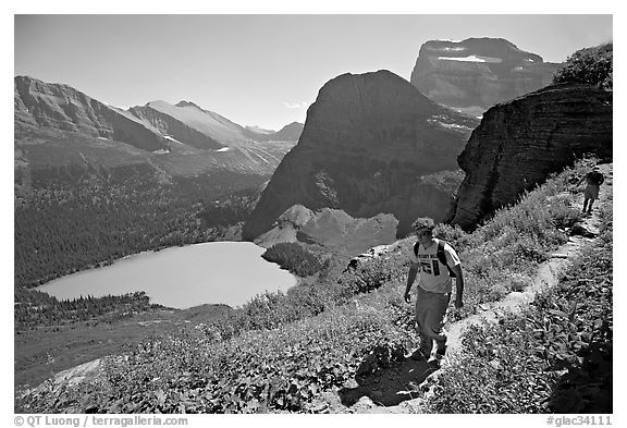 Hikers on trail overlooking Grinnell Lake. Glacier National Park, Montana, USA.