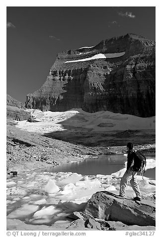 Hiker with backpack surveying Grinnell Glacier. Glacier National Park (black and white)