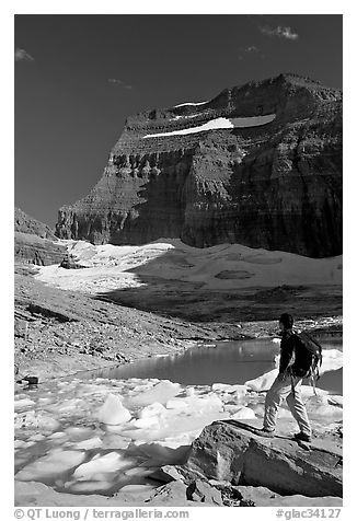 Hiker with backpack surveying Grinnell Glacier. Glacier National Park, Montana, USA.