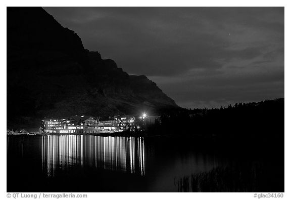 Many Glacier lodge lights reflected in Swiftcurrent Lake at night. Glacier National Park, Montana, USA.