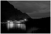Many Glacier lodge lights reflected in Swiftcurrent Lake at night. Glacier National Park, Montana, USA. (black and white)
