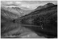 Kayaker paddling back to shore as clouds threaten, Kintla Lake. Glacier National Park ( black and white)