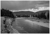 Dark clouds over North Fork of Flathead River in autumn. Glacier National Park ( black and white)