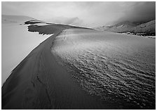 Zig-zag pattern of sand amongst Snow on the dunes. Great Sand Dunes National Park, Colorado, USA. (black and white)