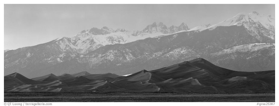 Sand dunes below snowy mountain range at sunset. Great Sand Dunes National Park and Preserve (black and white)