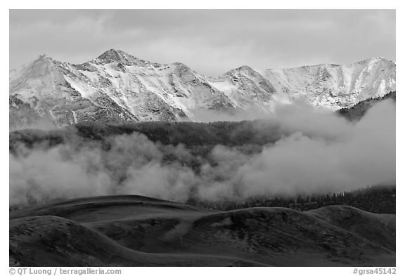 Snowy Sangre de Cristo Mountains and clouds above dune field. Great Sand Dunes National Park, Colorado, USA.