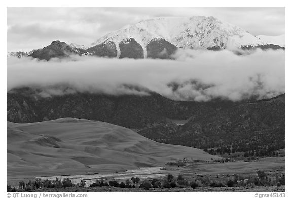 Dunes and Medano creek below snowy mountains. Great Sand Dunes National Park, Colorado, USA.