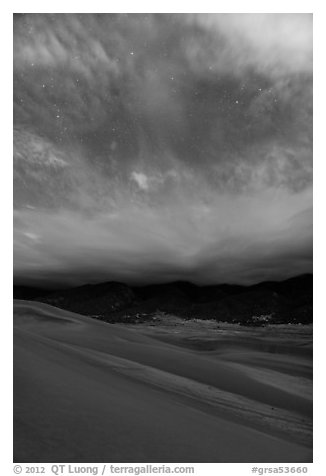 Dunes, moonlit clouds, and stars. Great Sand Dunes National Park, Colorado, USA.