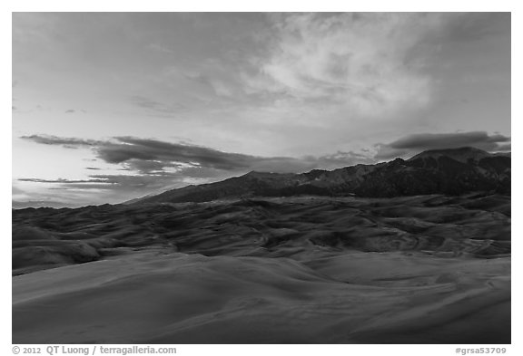 Dune field and Sangre de Cristo mountains with cloud lighted by sunset. Great Sand Dunes National Park, Colorado, USA.