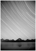 Star trails on Teton range above Jackson lake, dusk. Grand Teton National Park, Wyoming, USA. (black and white)