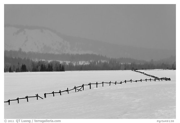 Wooden fence, snow-covered flat, hills in winter. Grand Teton National Park (black and white)