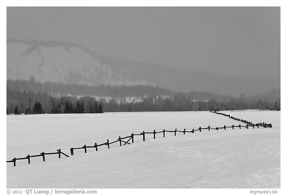 Wooden fence, snow-covered flat, hills in winter. Grand Teton National Park, Wyoming, USA.