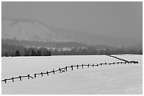 Wooden fence, snow-covered flat, hills in winter. Grand Teton National Park, Wyoming, USA. (black and white)