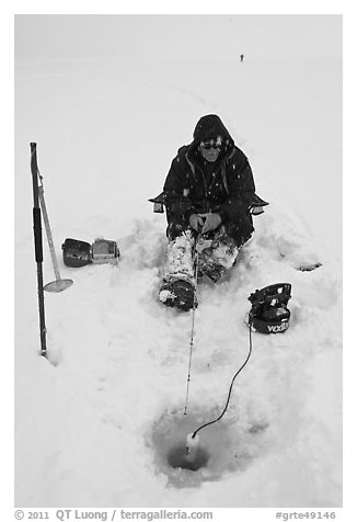 Man ice fishing with radar on Jackson Lake. Grand Teton National Park, Wyoming, USA.