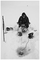 Man ice fishing with radar on Jackson Lake. Grand Teton National Park, Wyoming, USA. (black and white)