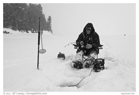 Ice fisherman in white-out, Jackson Lake. Grand Teton National Park, Wyoming, USA.