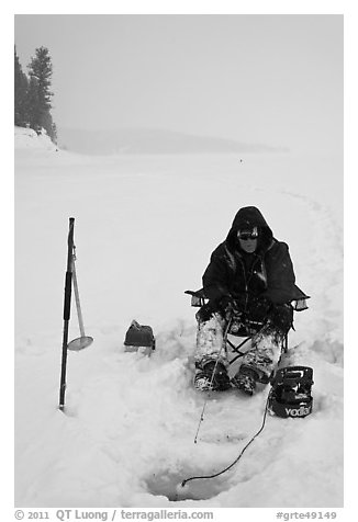 Ice fisherman with lounge chair and radar,Jackson Lake. Grand Teton National Park, Wyoming, USA.