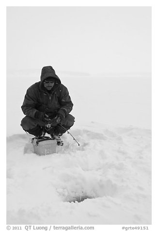 Ice fishing during a snow storm, Jackson Lake. Grand Teton National Park, Wyoming, USA.