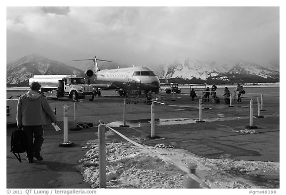 Passengers walking towards plane on Jackson Hole Airport. Grand Teton National Park, Wyoming, USA.