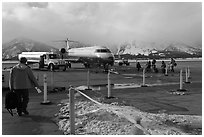 Passengers walking towards plane on Jackson Hole Airport. Grand Teton National Park, Wyoming, USA. (black and white)