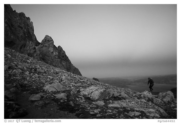 Mountaineer jumps on boulder at Lower Saddle,dusk. Grand Teton National Park (black and white)