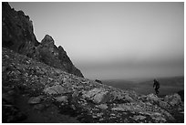 Mountaineer jumps on boulder at Lower Saddle,dusk. Grand Teton National Park ( black and white)