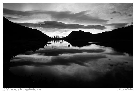 Colorful sunrise clouds reflected in a pond in Horseshoe park. Rocky Mountain National Park (black and white)