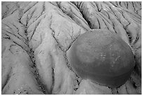 Cannonball concretion partly uncovered by erosion. Theodore Roosevelt National Park, North Dakota, USA. (black and white)