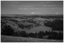 Rolling hills with distant lightening storm at dusk. Wind Cave National Park, South Dakota, USA. (black and white)
