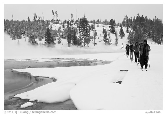 Cross country skiers pass Chromatic Spring. Yellowstone National Park, Wyoming, USA.